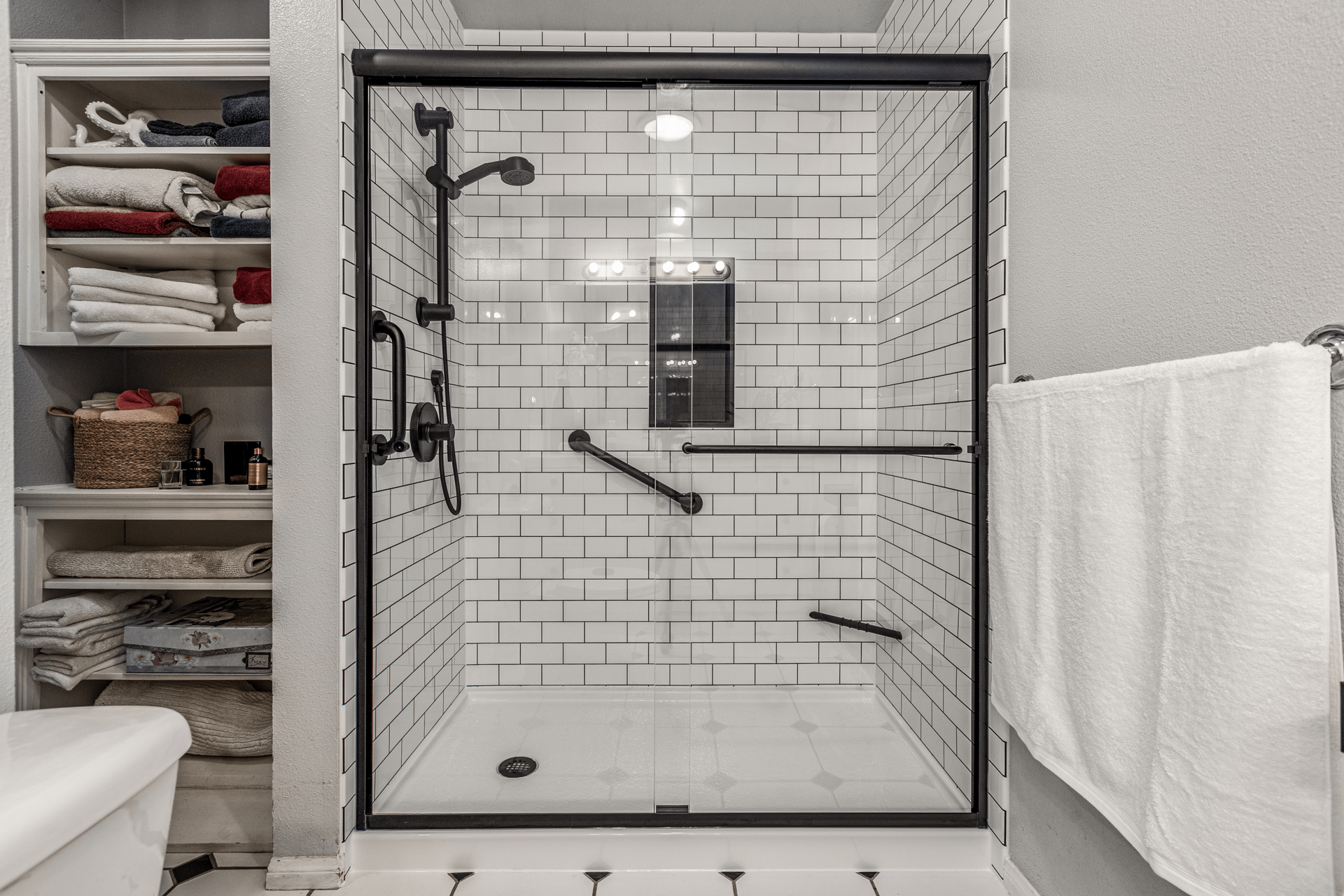 A beautifully remodeled walk-in shower with a clear sliding glass door