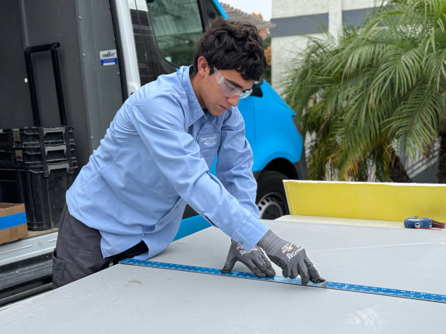 A Shugarman's Bath Assistant installer taking measurements on a backer board
