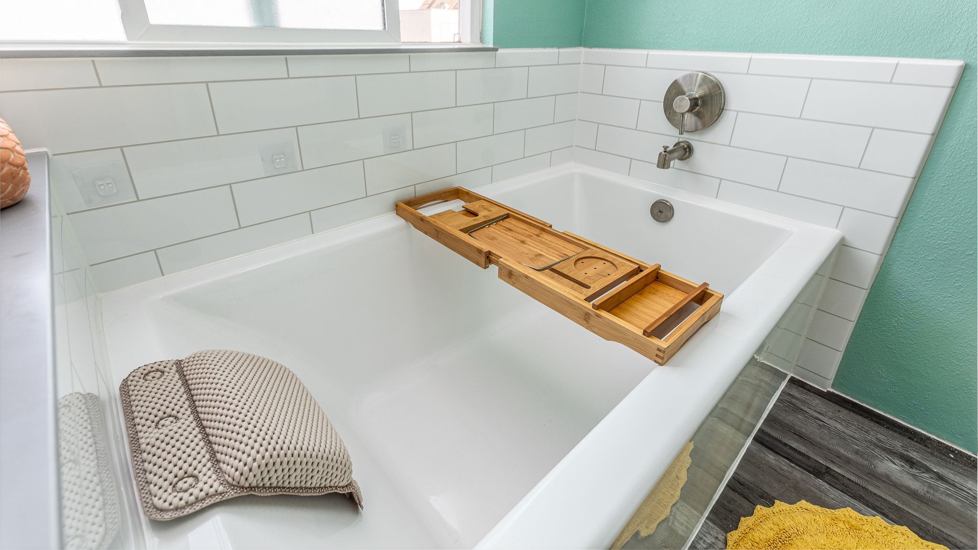 A newly finished shower-to-tub conversion with a white tub and tile-patterned walls.