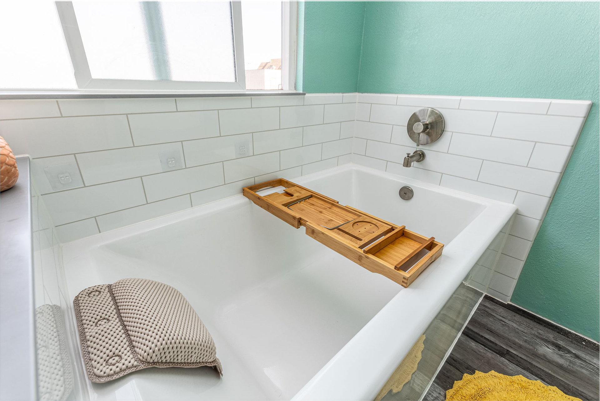 A newly finished shower-to-tub conversion with a white tub and tile-patterned walls.