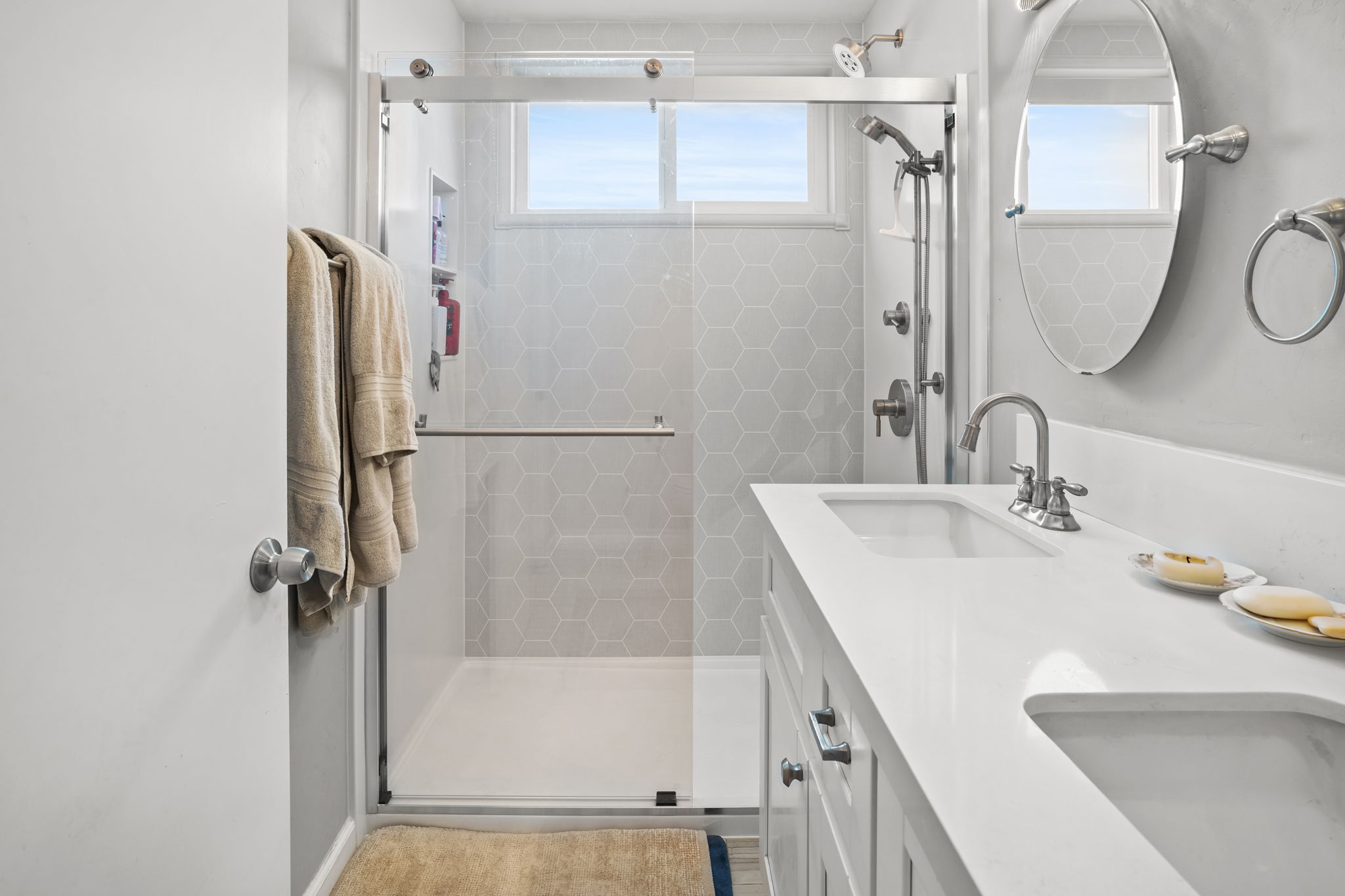 Beautiful remodeled shower with a handheld shower head, i fixed shower head, and a sliding-glass doorBeautiful remodeled shower with a handheld shower head, i fixed shower head, and a sliding-glass door