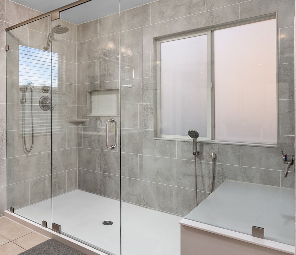 Extra large shower with custom bench and custom frameless pivot doors