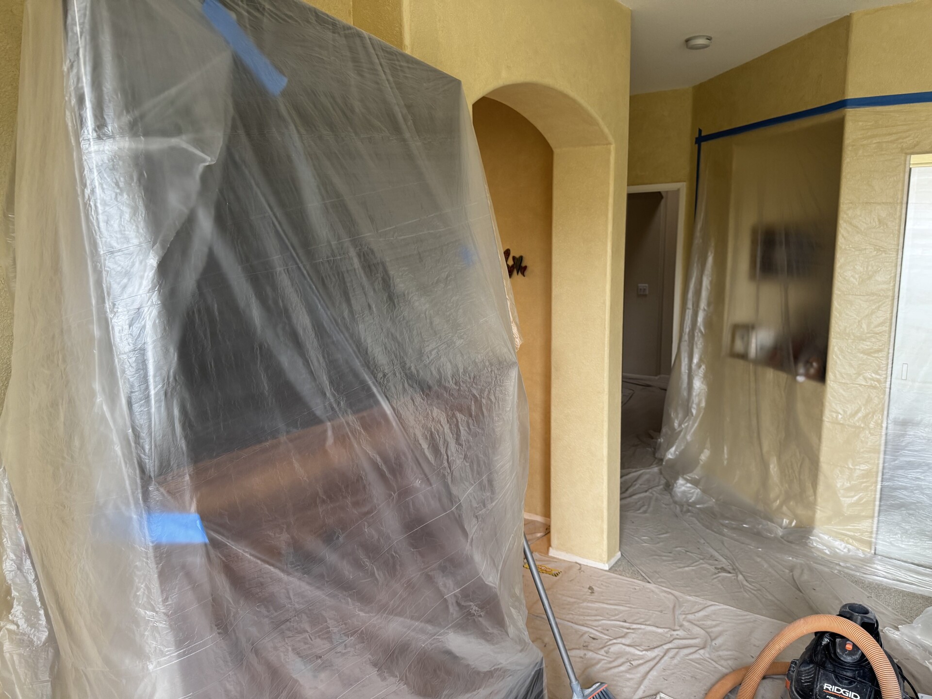 Inside a home with furniture and floors protected before a demolition.