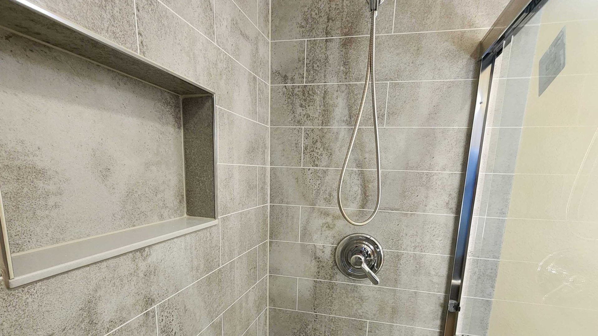 A remodeled shower with a shower storage niche
