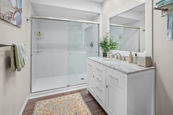Inside a bathroom with a walk-in shower that has two corner storage shelves