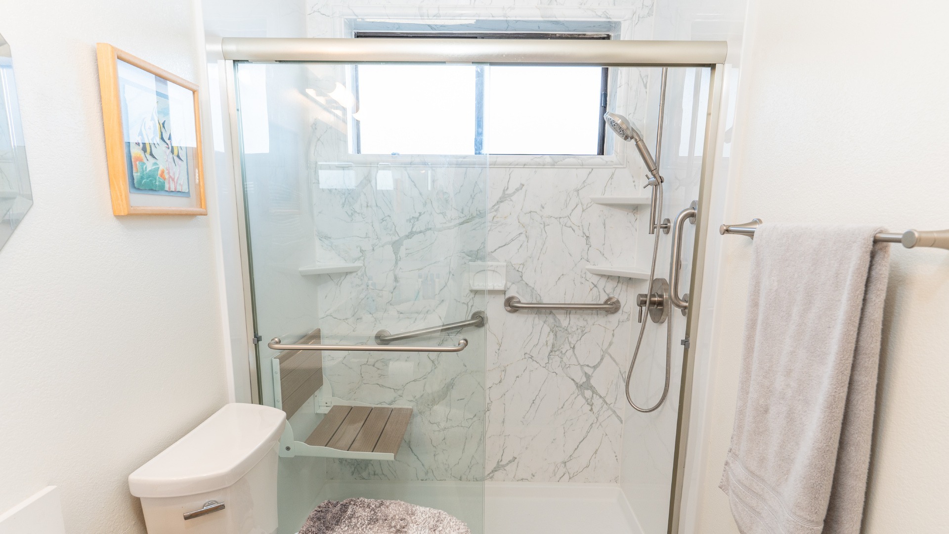 A walk-in shower with a handheld shower head, three grab bars, three corner storage shelves, and a folding shower seat.