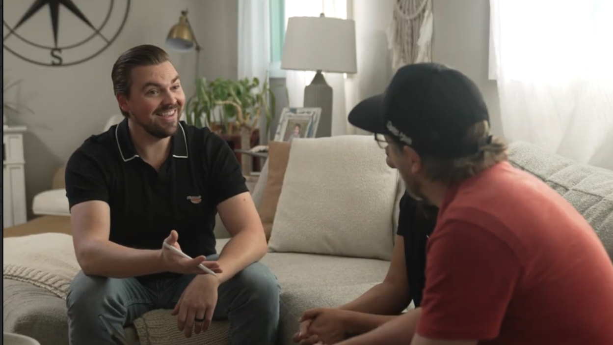 Sales team speaking with two homeowners in their living room area
