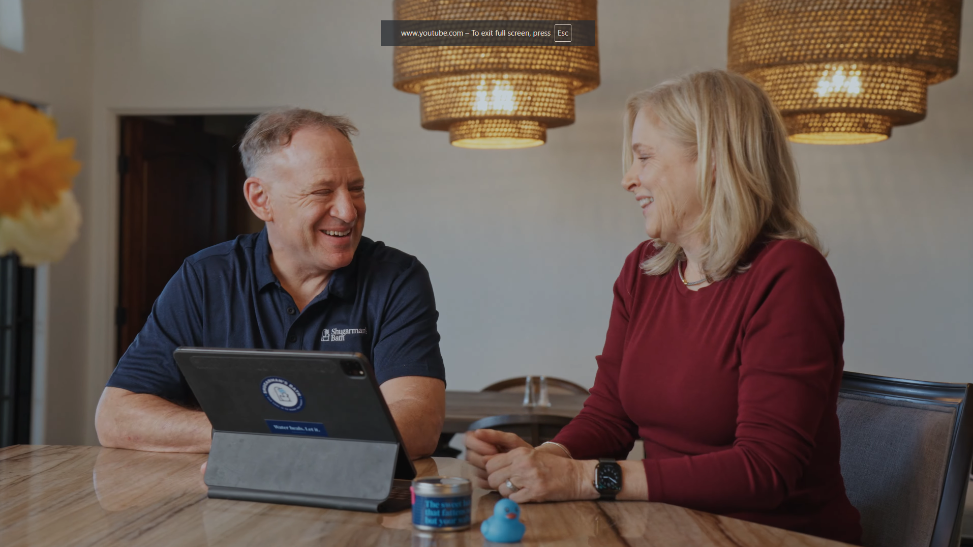 A customer and design consultant happily discussing a bathroom remodel