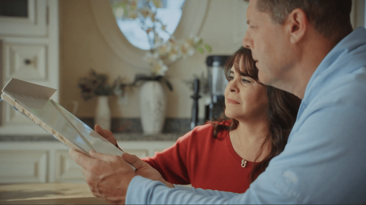 A couple looking at a piece of shower wall material during their consultation.