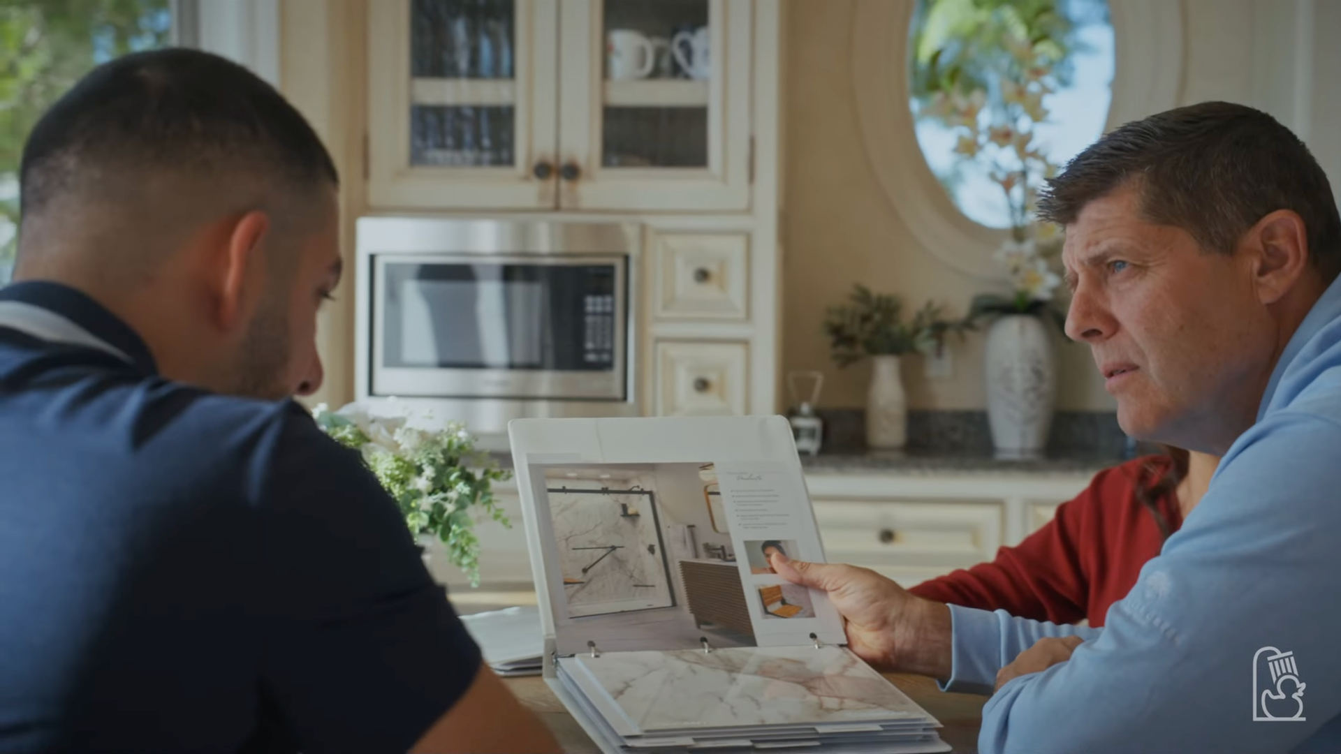 A design consultant is talking to a homeowner about shower remodeling before going into the remodel cost.