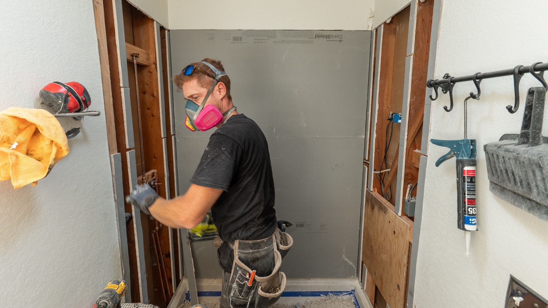 A Shugarman's Bath installer in the process of waterproofing the tub and shower area.