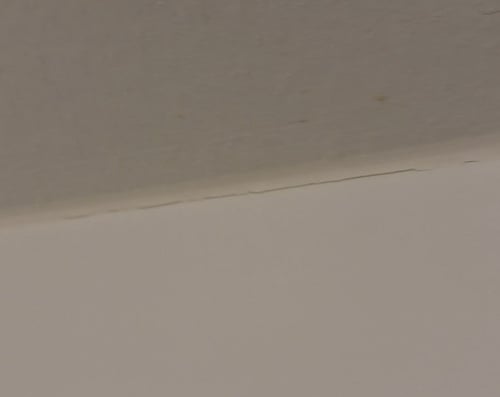 Cracked silicone at the top of a shower wall