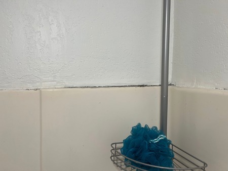A fiberglass tub with old caulking that is separating.
