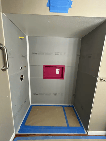 A waterproofed shower with the exposed DensShield backer board before surface walls are put up.