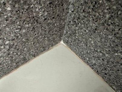 Silicone drying and cracking between a bathtub and shower walls.