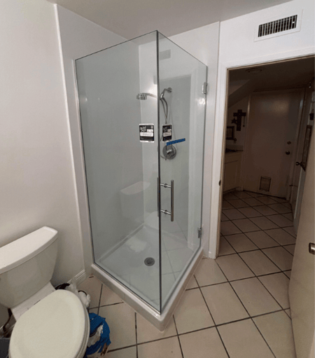 a walk-in shower with a clear glass enclosure