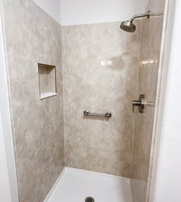A walk-in shower with Travertine walls