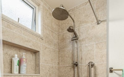 A shower with brushed nickel fixtures and shower heads
