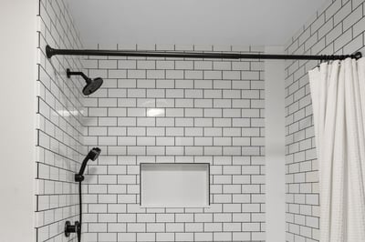 A shower with subway tile pattern walls and seam trim