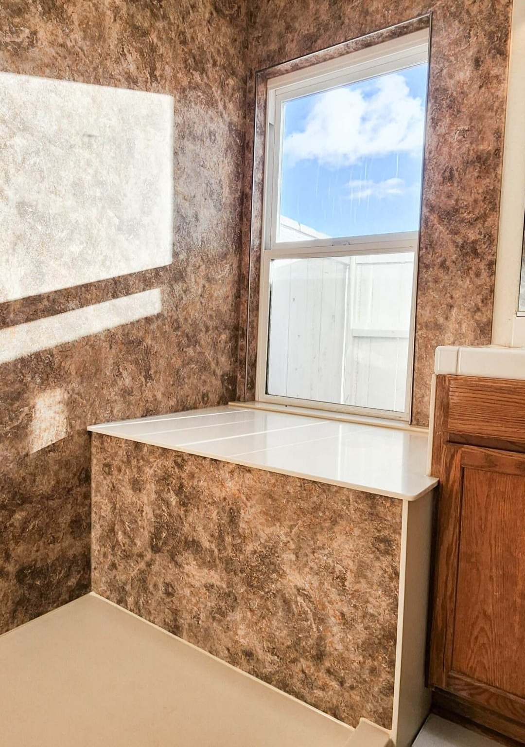 A walk-in shower with a custom bench built under a window